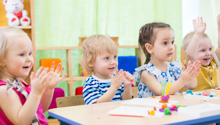 Kinder sitzen an einem Tisch und spielen