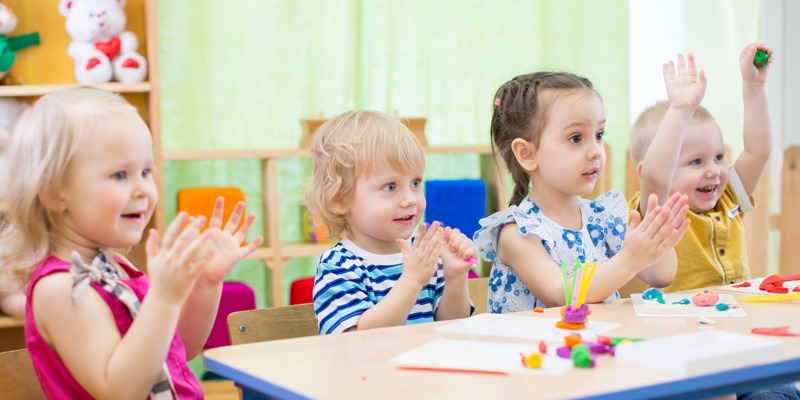 Kinder sitzen an einem Tisch und spielen